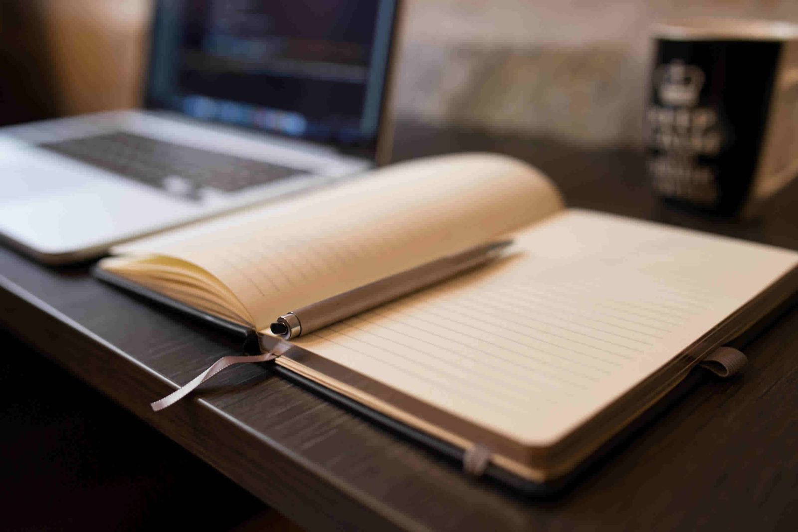 Caderno aberto com caneta sobre uma mesa de escritório, representando a organização de um planejamento sucessório