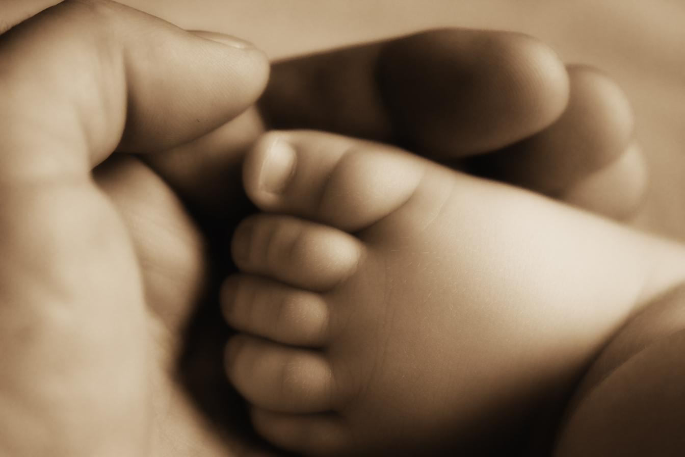 Pai caminhando de mãos dadas com a filha na praia, representando o vínculo de convivência mesmo em casos de guarda exclusiva